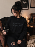 Model wearing black embroidered sweatshirt with 'just a little ray of pitch black' tonal embroidery